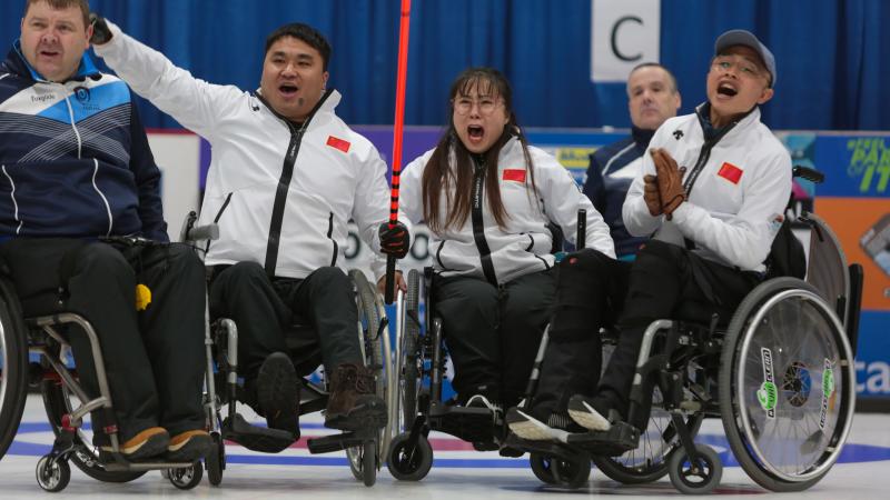Three Chinese wheelchair curlers celebrate expressively on the ice